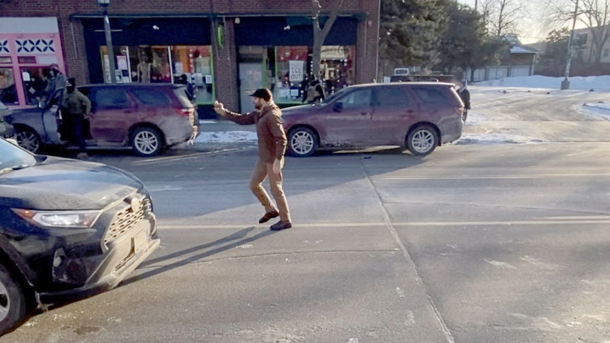 A video still shows a man holding a mobile phone shortly before a confrontation with law enforcement.