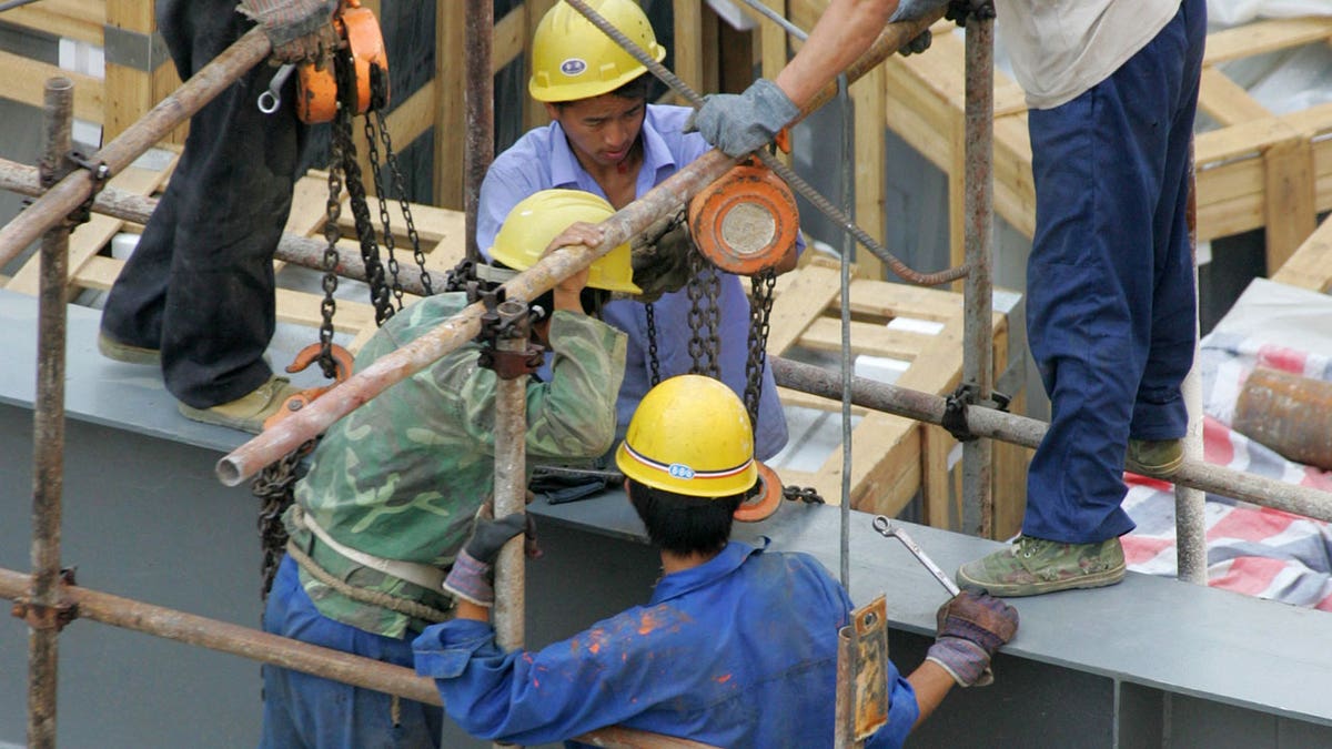 Chinese labourers work at a construction site