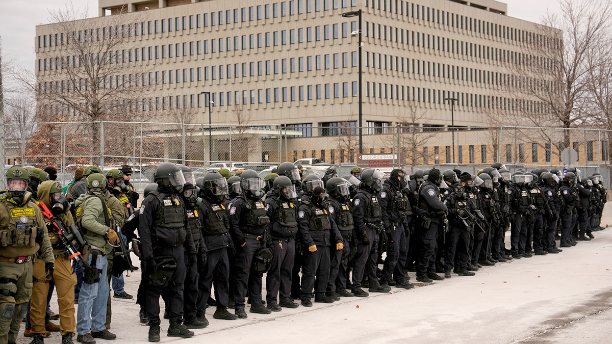 Federal immigration officers stand in line outside Minneapolis federal building