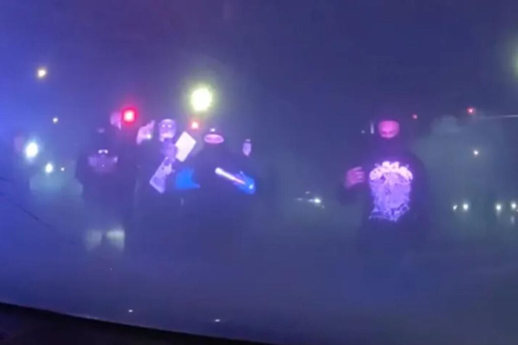 Masked mob attacks police cruiser with officer inside during illegal street takeover