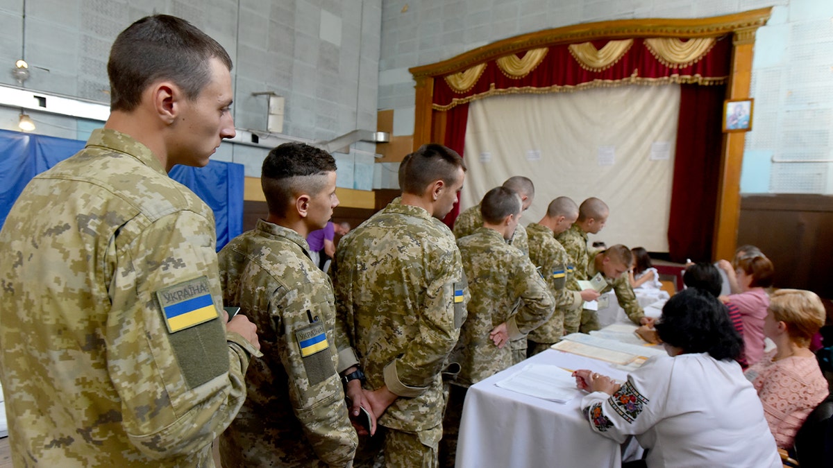Uniformed soldiers stand inside a polling station as they take part in the voting process.