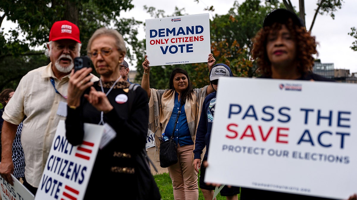 People with signs supporting the SAVE act at Upper Senate Park