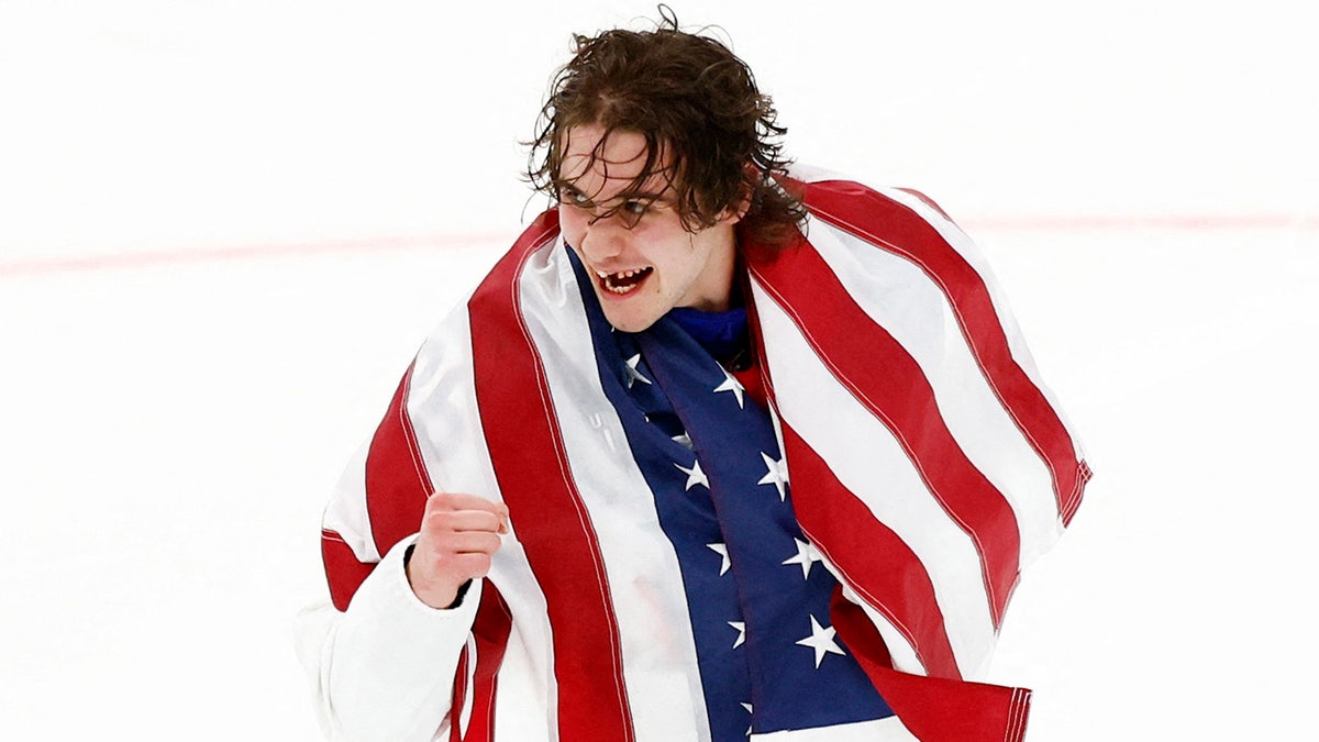 Jack Hughes holds the American flag