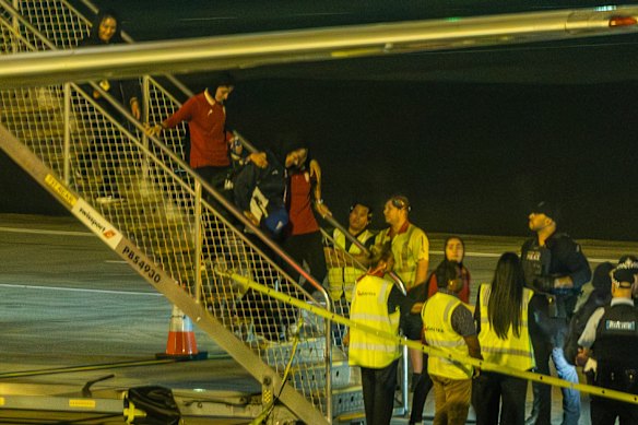 The Iranian women’s soccer team is taken from the plane to a bus at Sydney Airport on Tuesday night. 