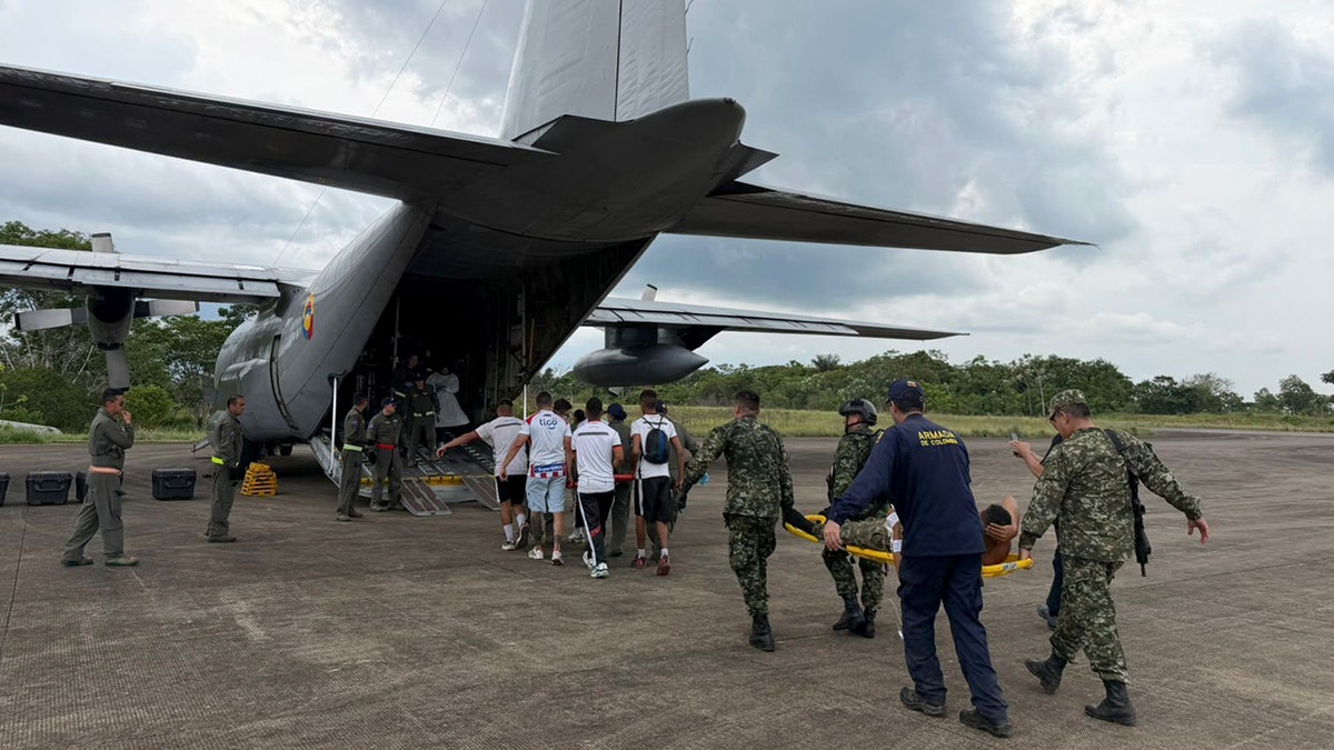 Injured people are loaded onto a plane on stretchers.