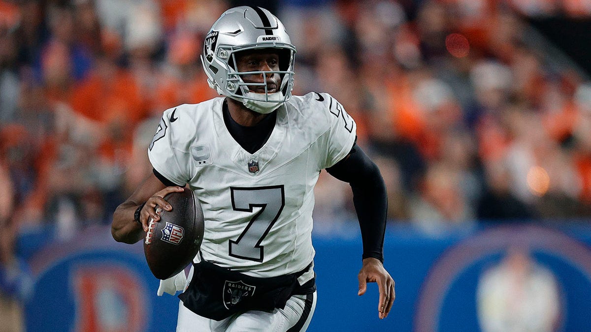 Geno Smith drops back to pass during a game