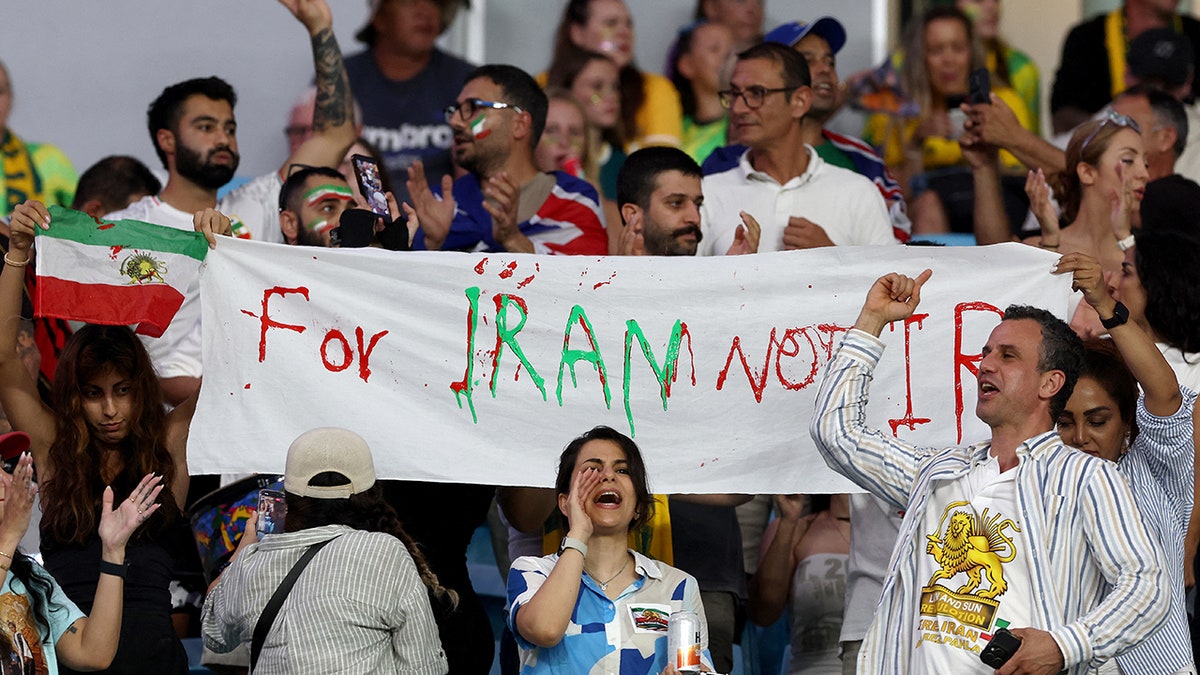 Iranian supporters hold a banner