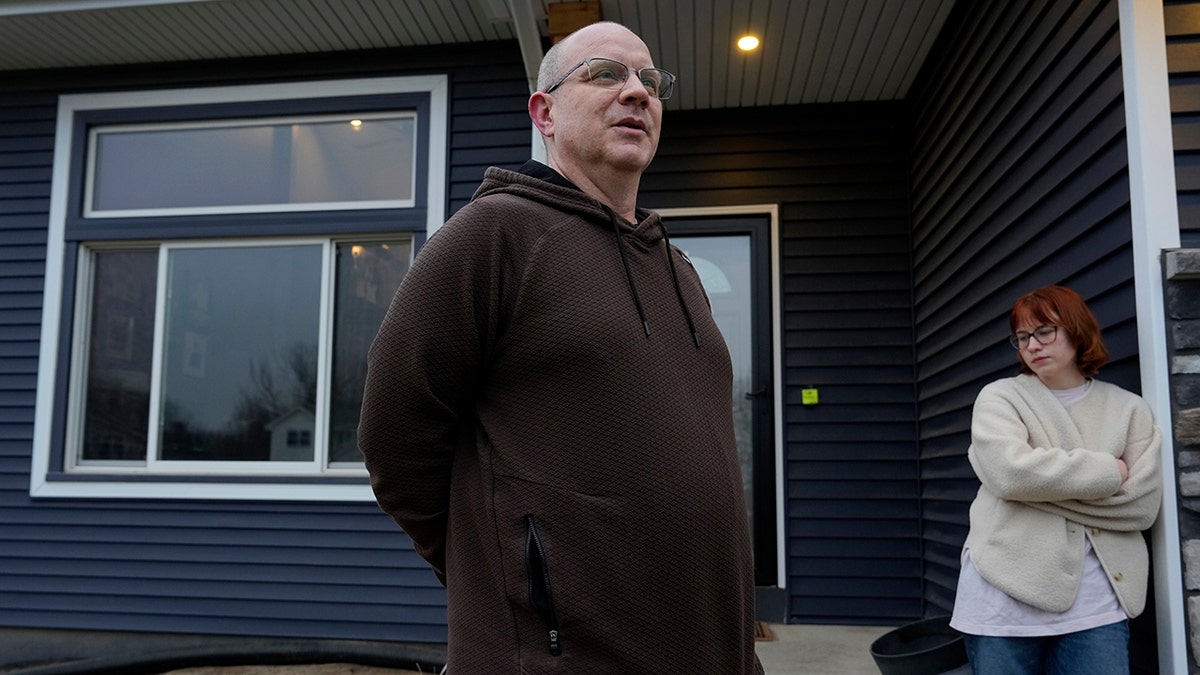 Andrew Coady and Keira Coady talking outside their home in West Des Moines, Iowa.