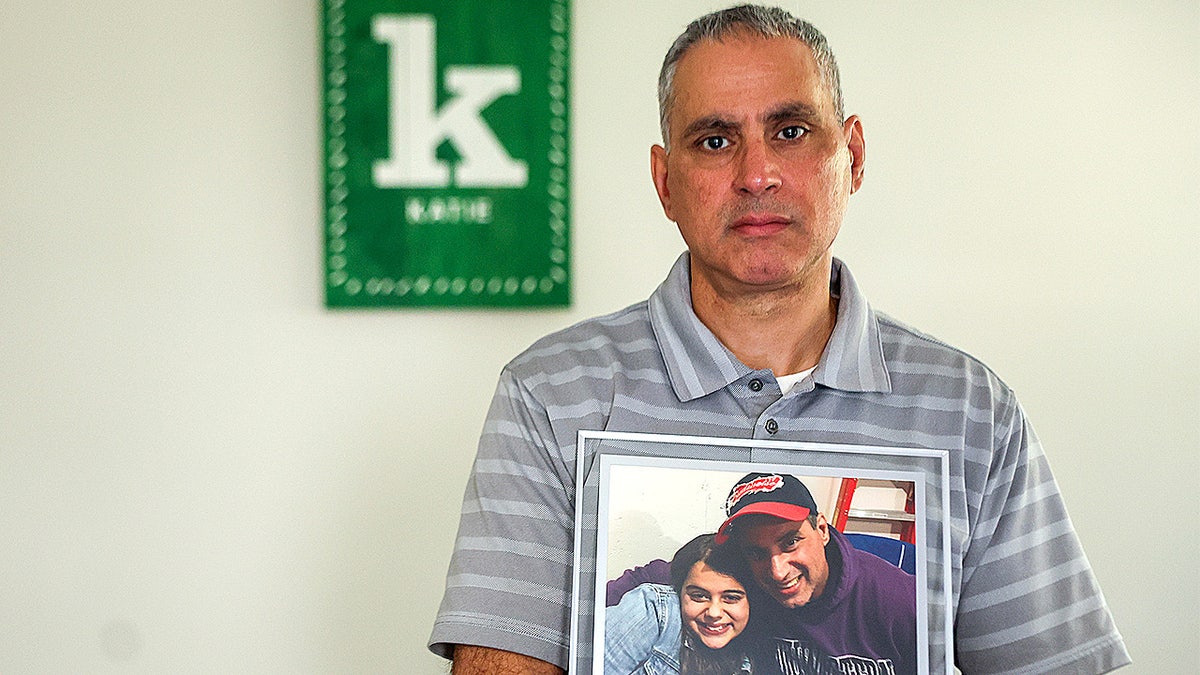 Joe Abraham holds photo of himself and daughter Katie.