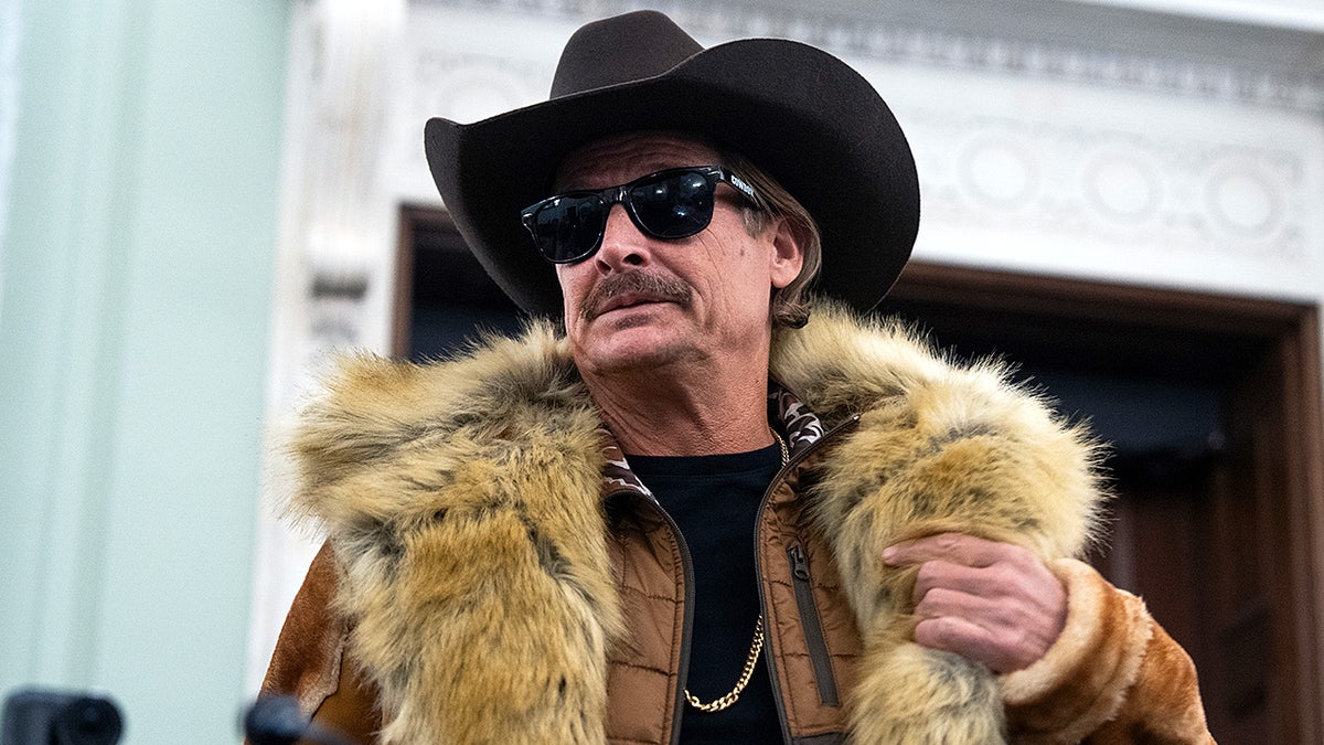 Kid Rock walks through a government building hallway while arriving for a Senate hearing.
