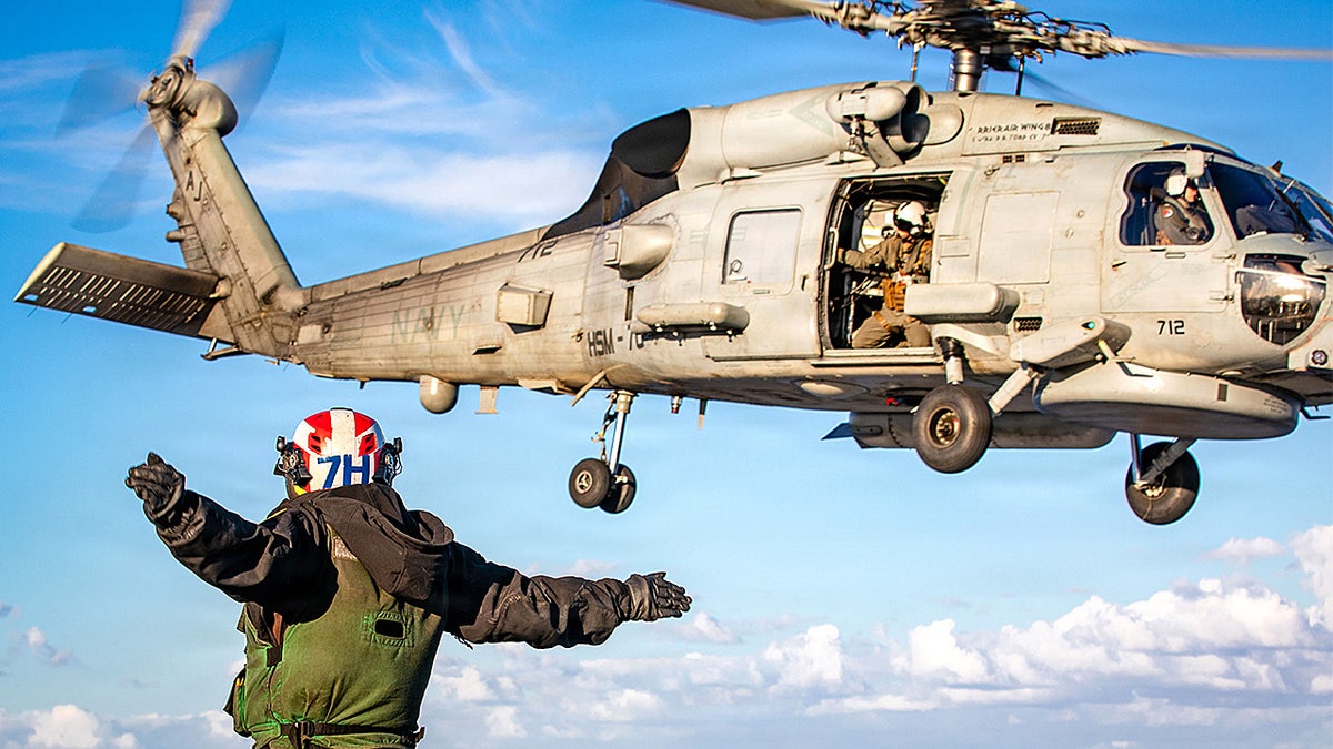 U.S. sailor signals helicopter launch on USS Gerald R. Ford.