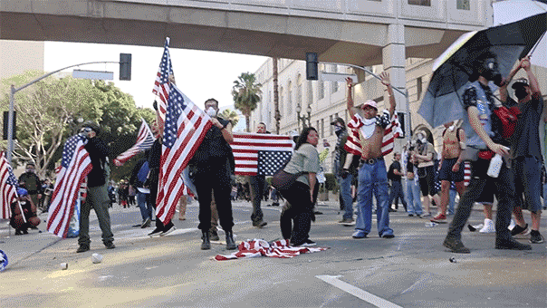 Rioters wave American flags in Los Angeles, CA.