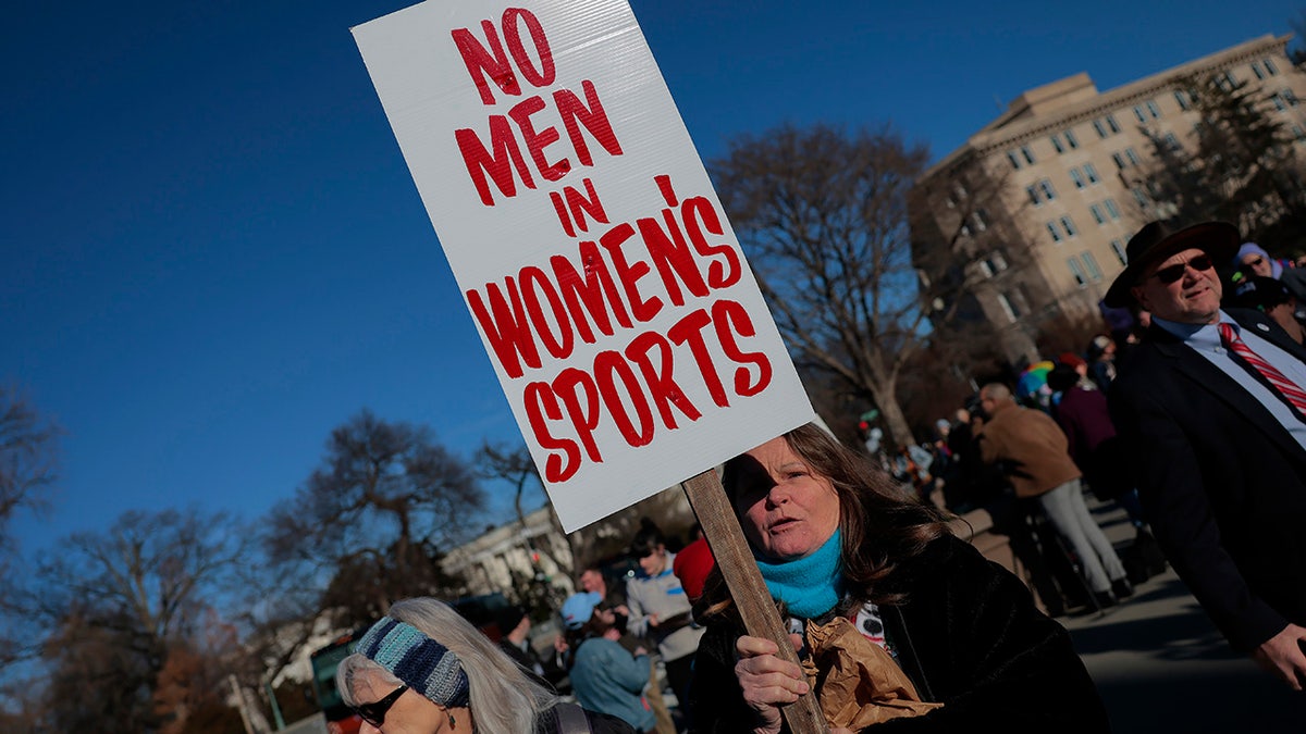 Protester Heather Diehl holding No men in women's sports sign outside Supreme Court in Washington D.C.
