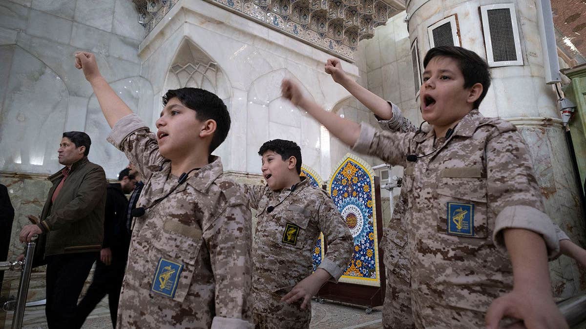 Iranian schoolboys wear Islamic Revolutionary Guard Corps military uniforms