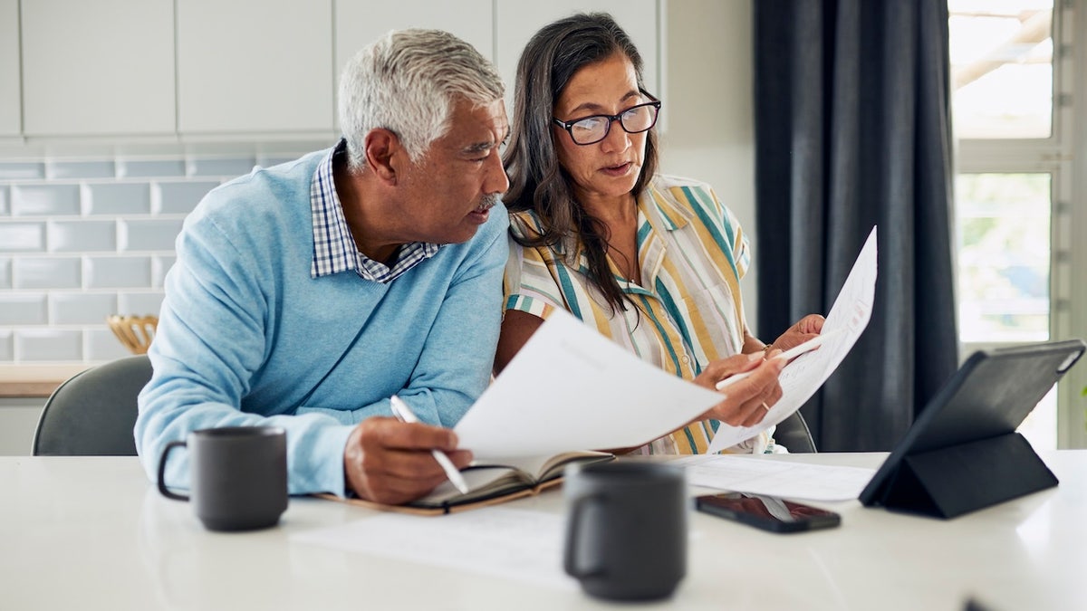A couple reviewing tax paperwork at a table