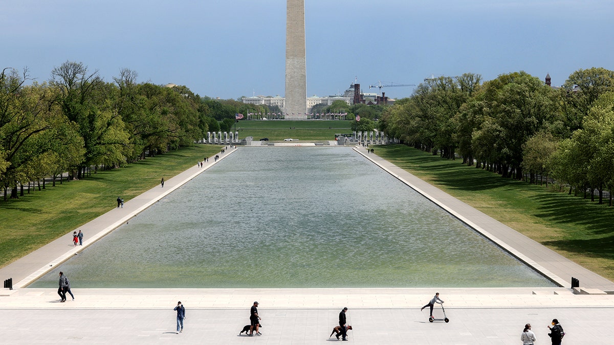 People enjoying outdoors in front of Lincoln Memorial Reflecting Pool with Washington Monument in background