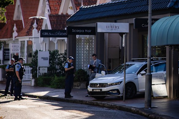 Police gather outside the luxury consignment store on Thursday. 