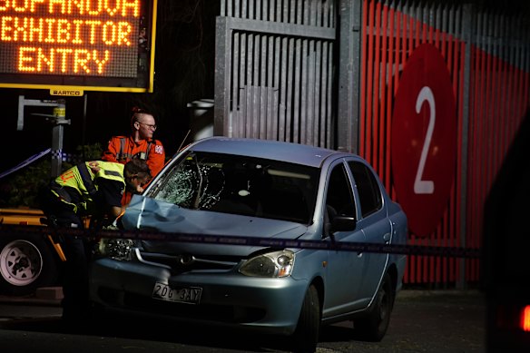 Police examine the silver Toyota involved in the crash.