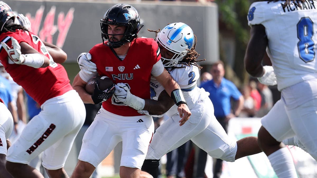 Linebacker Red Murdock tackles a player from an opposing team