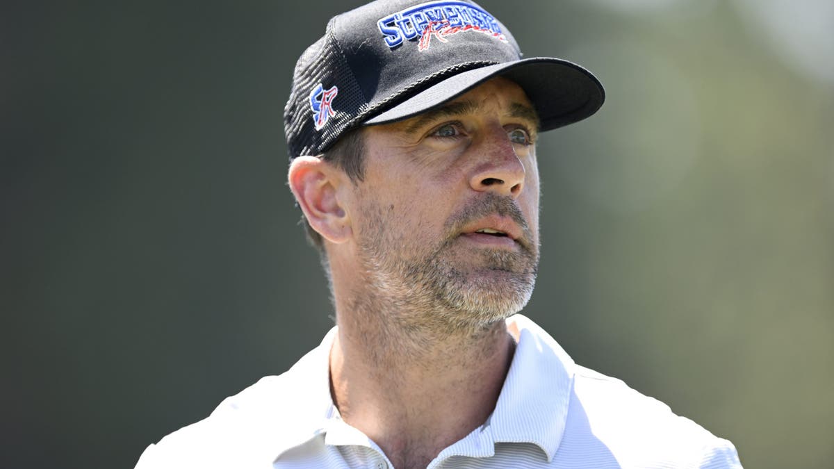 Aaron Rodgers looks on during a golf event