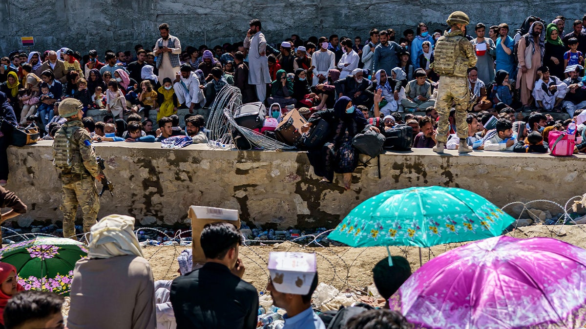 British and American security forces maintaining order among Afghan evacuees inside Abbey Gate in Kabul