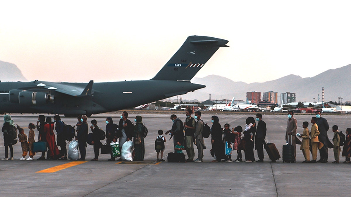 Evacuees waiting to board a Boeing C-17 Globemaster III at Hamid Karzai International Airport in Kabul