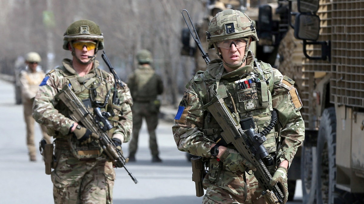 British soldiers in military gear moving through a secured area in Kabul