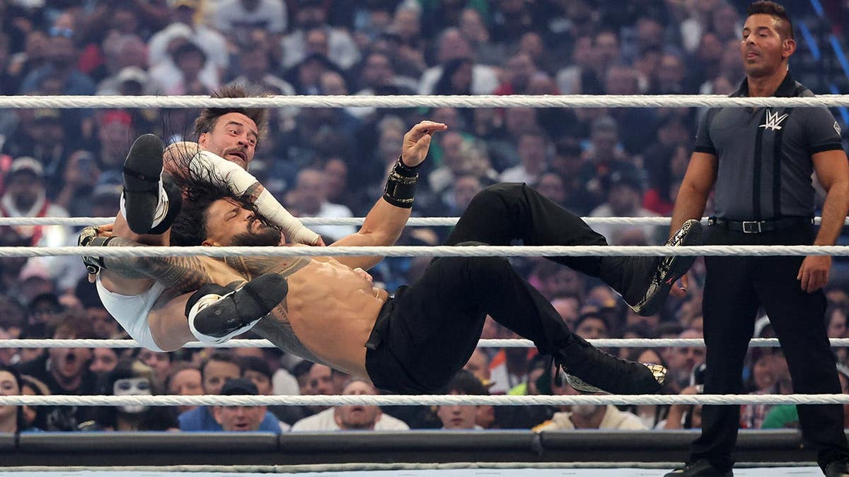 CM Punk fighting Roman Reigns in a wrestling match at Allegiant Stadium