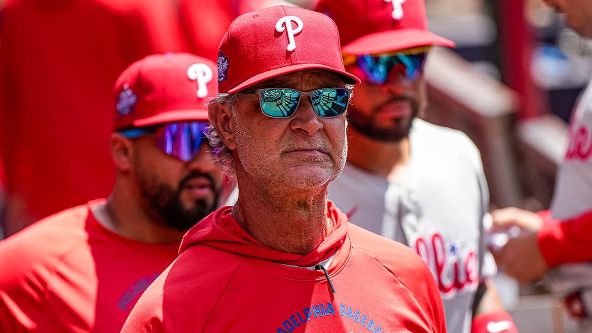 Philadelphia Phillies bench coach Don Mattingly standing in the dugout at Truist Park