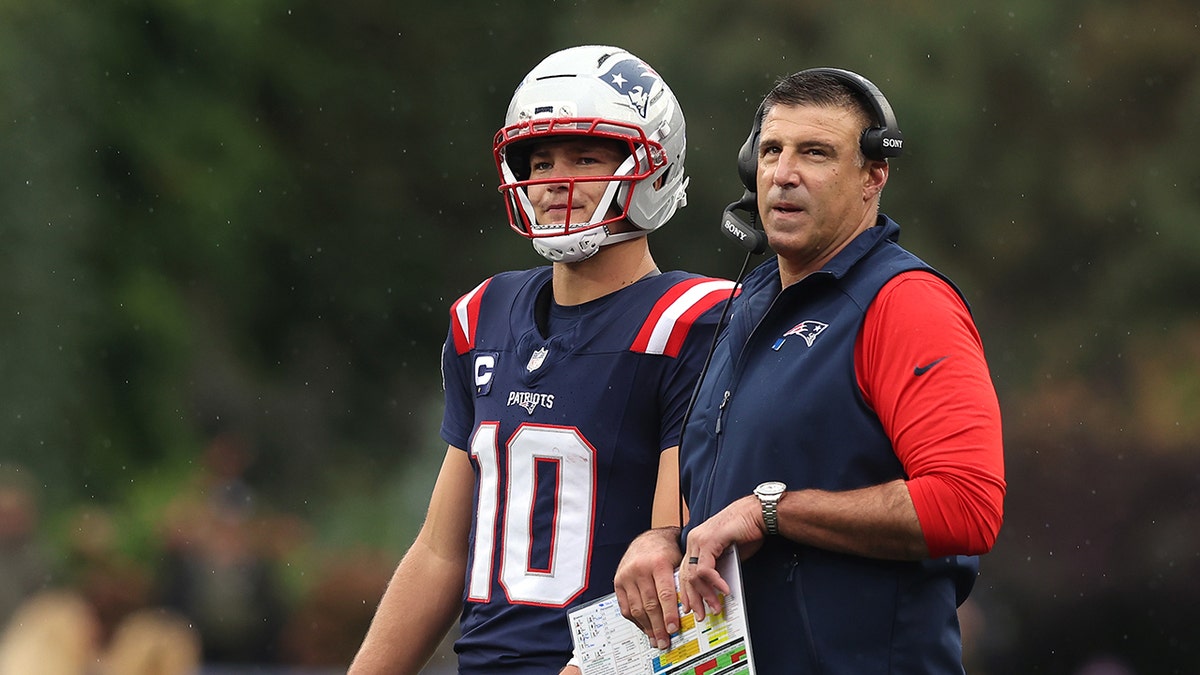 Head coach Mike Vrabel speaking with quarterback Drake Maye on the sidelines at Gillette Stadium