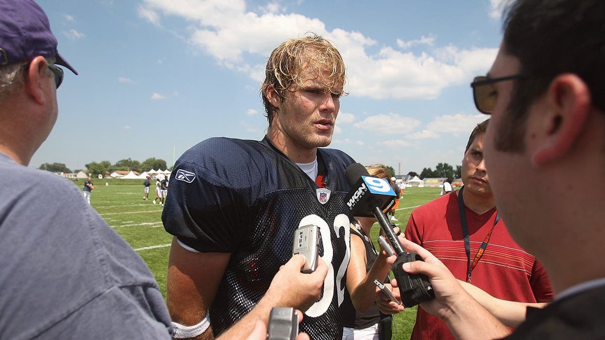 Greg Olsen wearing Chicago Bears uniform talking to reporters at training camp