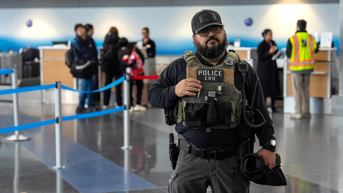 ICE agents walking through a terminal at JFK Airport.