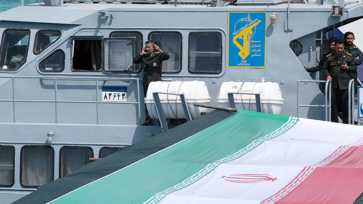 Islamic Revolutionary Guard Corps Navy personnel standing on a warship deck during a parade near Bushehr nuclear power plant
