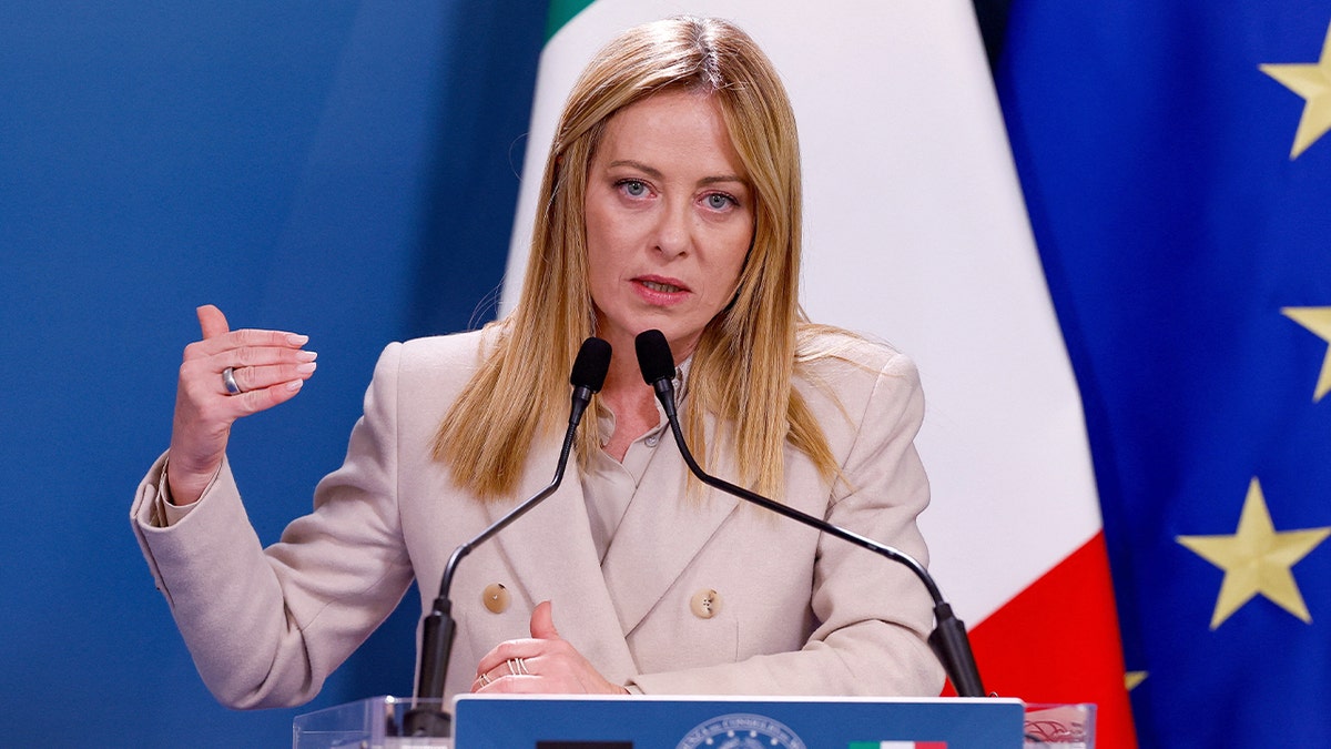 Italian Prime Minister Giorgia Meloni speaking at a podium during government consultations in Rome