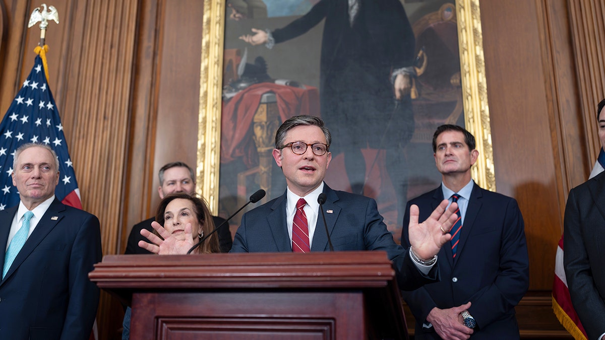 Speaker of the House Mike Johnson speaking at a podium during a news conference at the Capitol in Washington