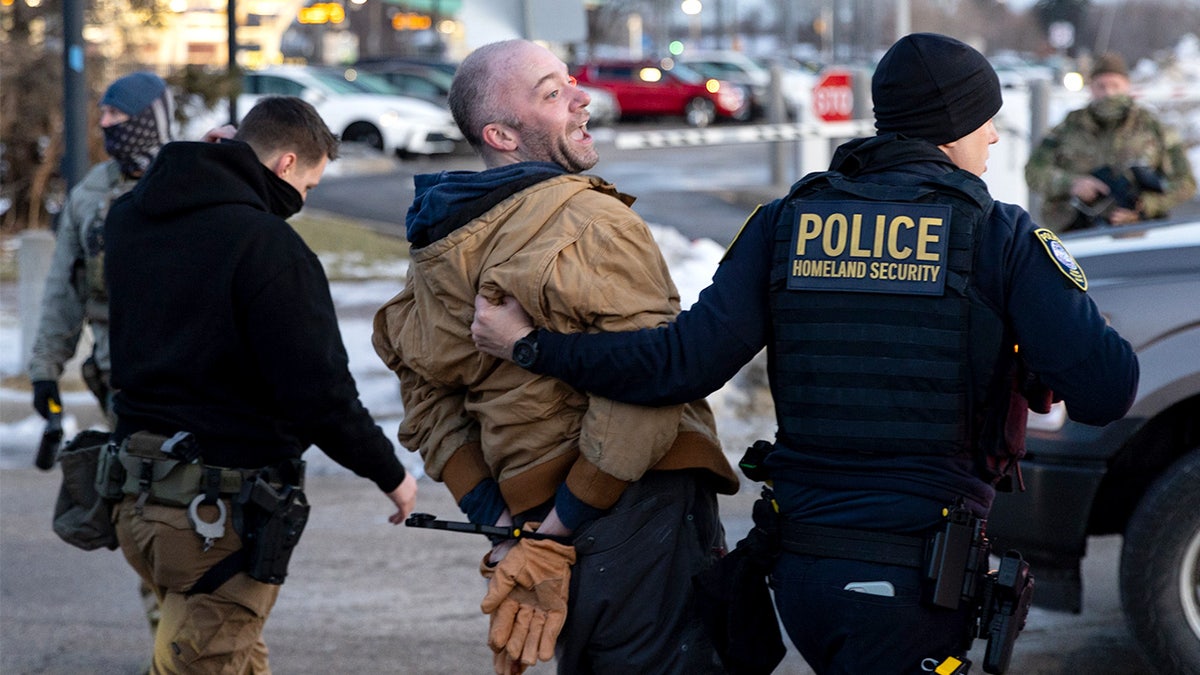 Federal agents arrest an anti-ICE agitator outside an ICE facility in Minneapolis.