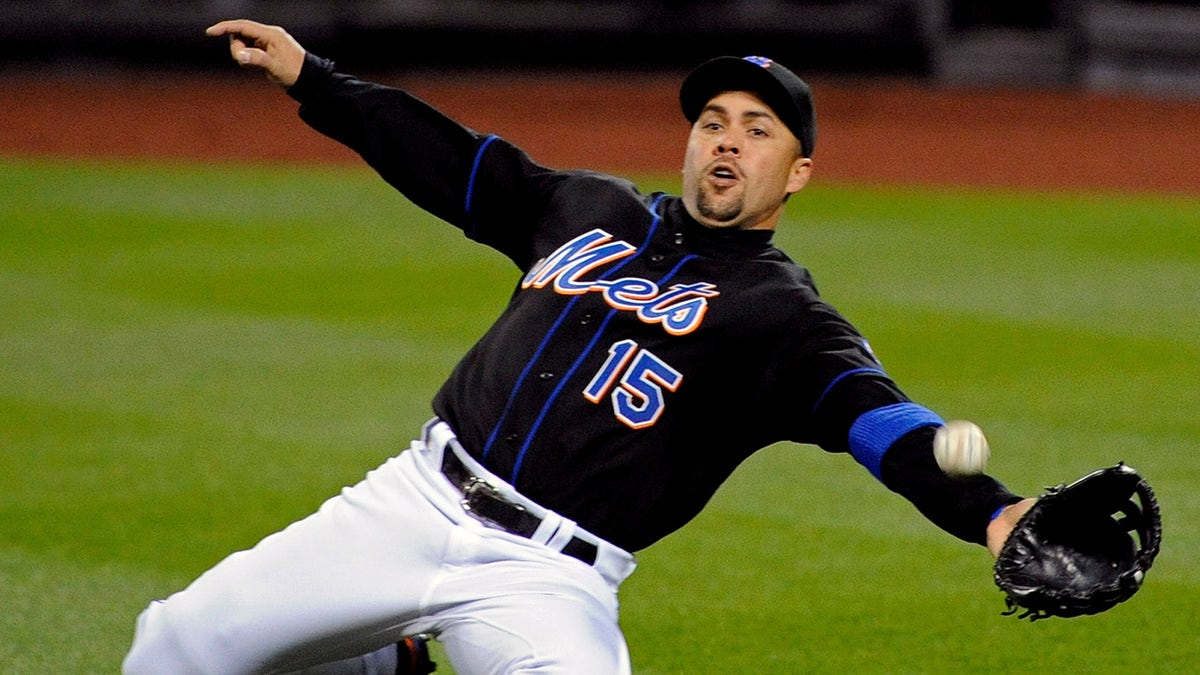 New York Mets right fielder Carlos Beltran lunging to catch a baseball during a game.