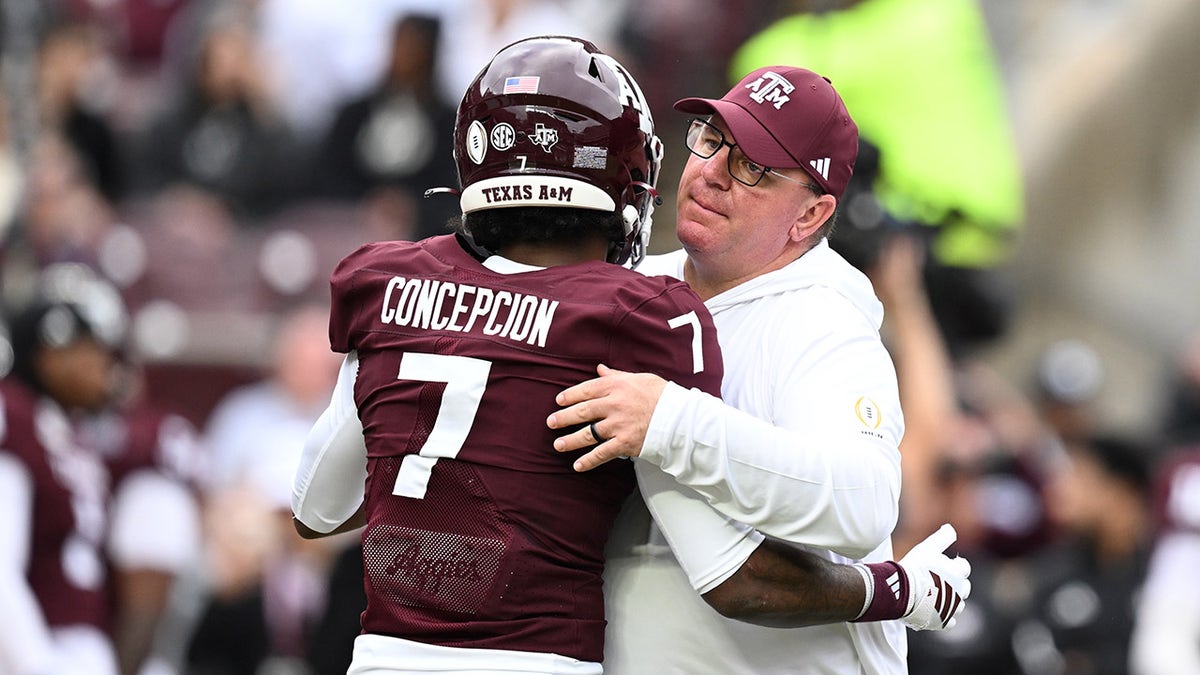 Texas A&M Aggies head coach Mike Elko hugging wide receiver KC Concepcion at Kyle Field
