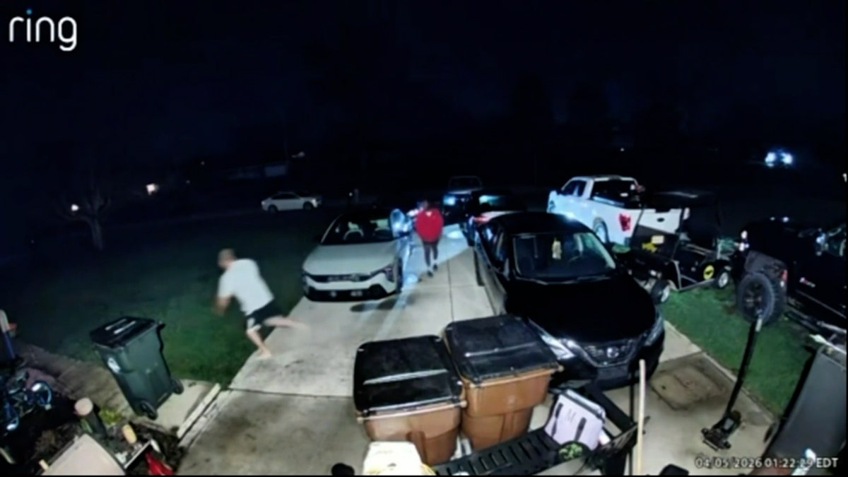 a man runs away from a suspect outside on the driveway