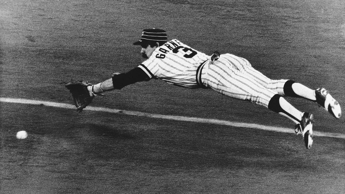 Pirates Phil Garner diving to catch ball during baseball game
