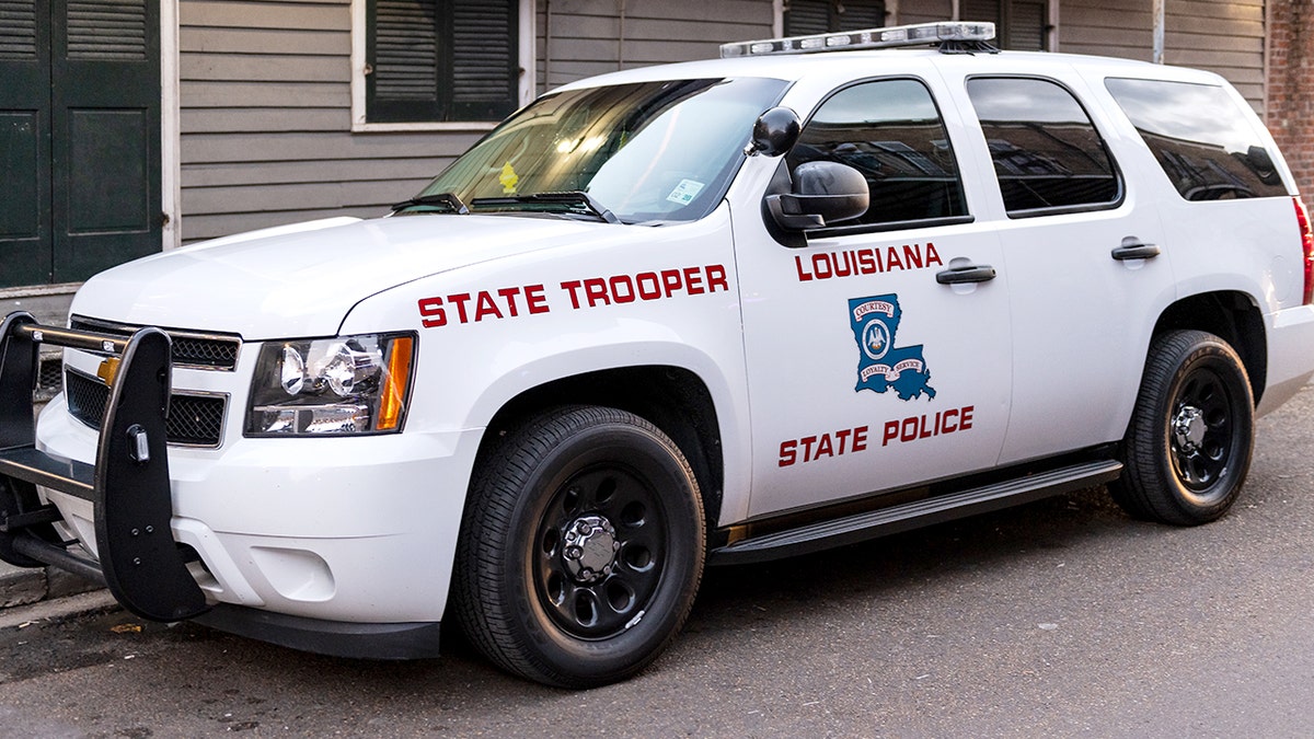 A Louisiana State Police vehicle is parked on the street.