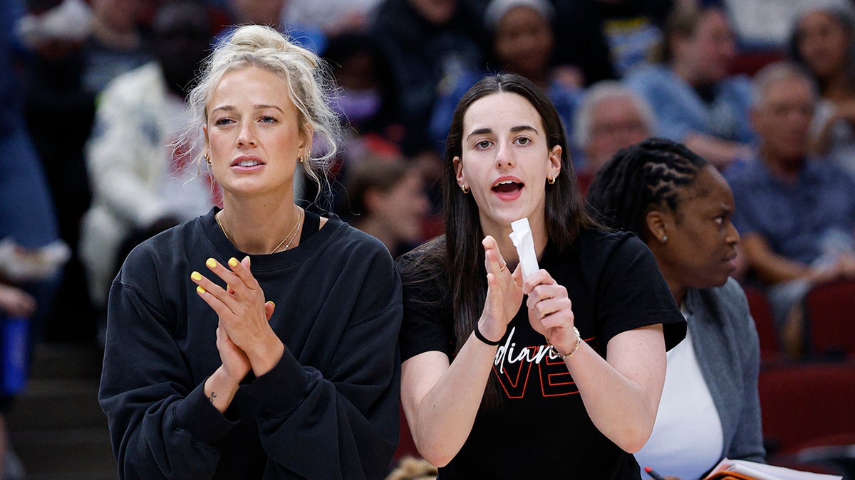 Injured Sophie Cunningham and Caitlin Clark sitting on bench during WNBA game