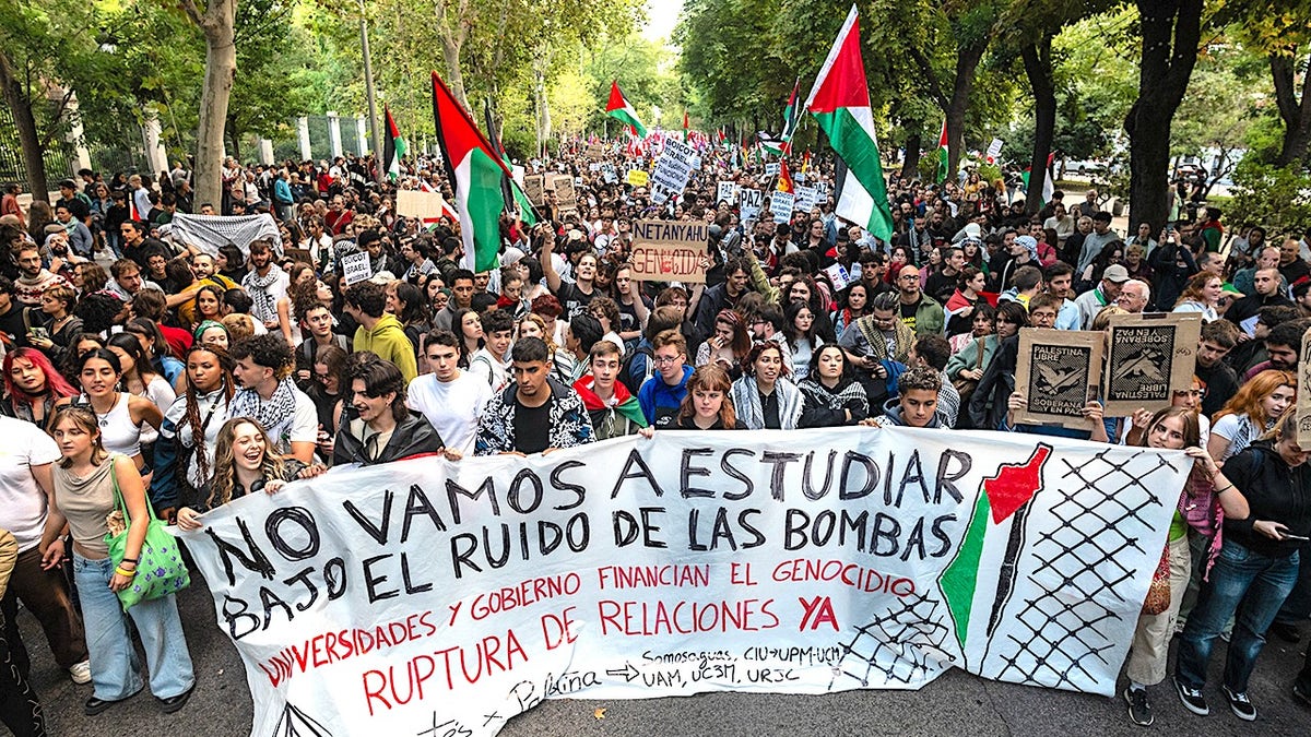 Spaniards holding signs and flags protesting against Israel in a street demonstration