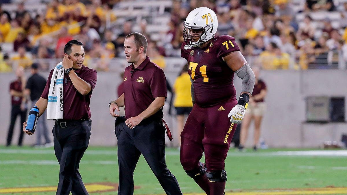 Arizona State Sun Devils offensive lineman Steven Miller walking off the field injured