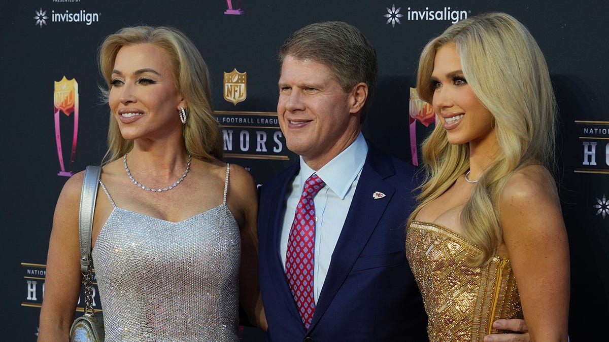 Clark Hunt standing on red carpet with wife Tavia Hunt and daughter Gracie Hunt