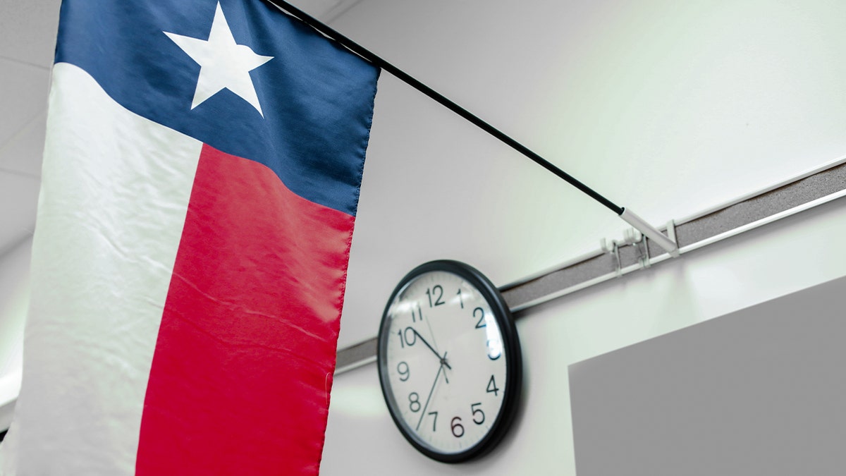 A Texas high school classroom with state flag and clock