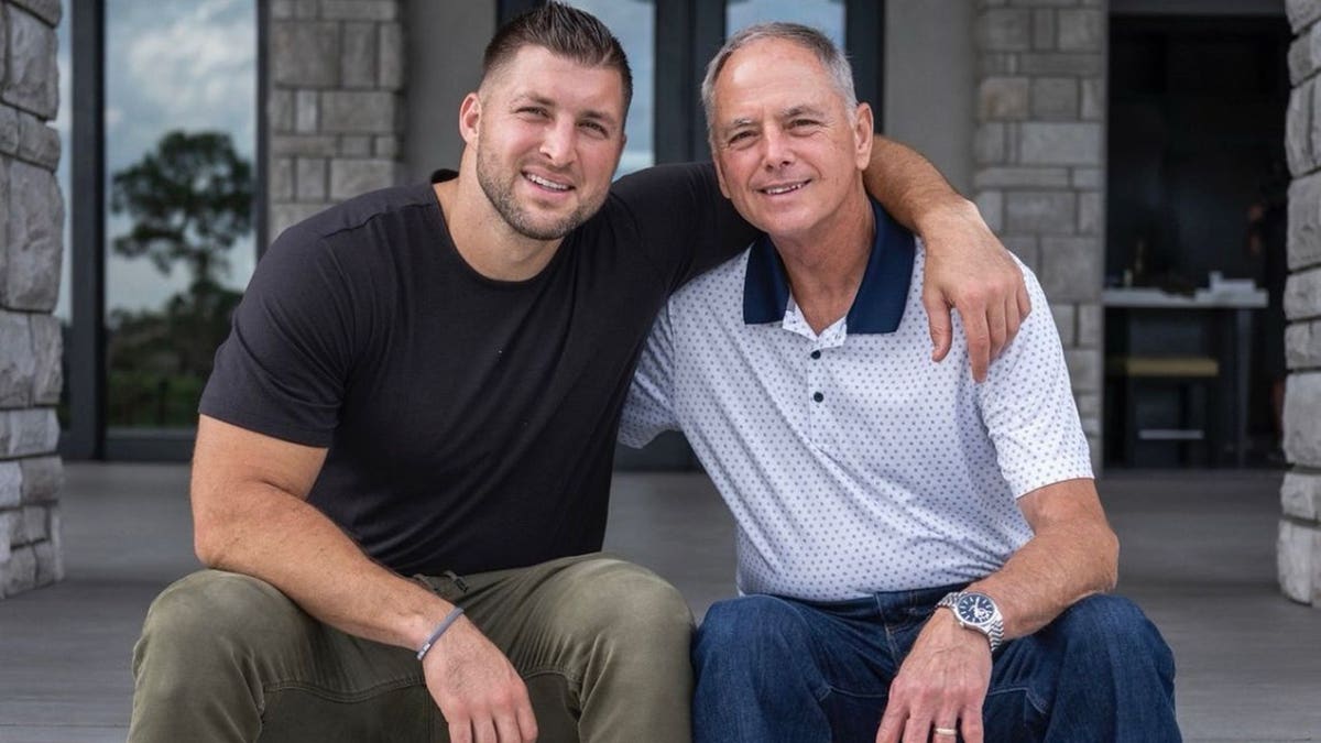 Tim Tebow and father, Bob Tebow, sitting on porch steps smiling with arms around eachother.