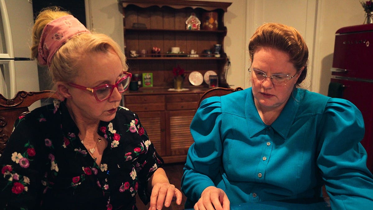 Christine Marie and Julia Johnson standing together in a scene from Trust Me: The False Prophet Season 1