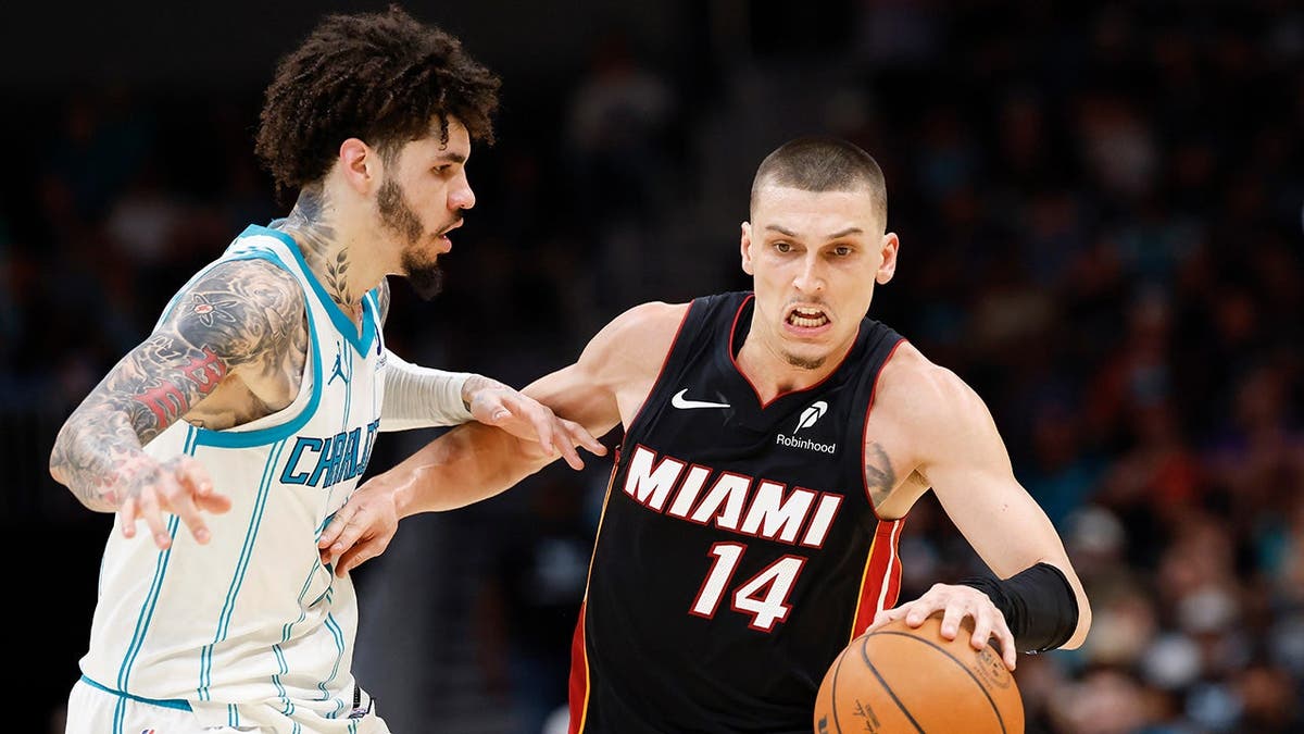 Tyler Herro driving against LaMelo Ball during an NBA play-in game in Charlotte