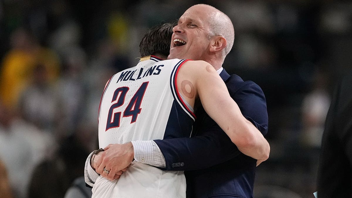 UConn's Braylon Mullins and head coach Dan Hurley celebrating on basketball court.